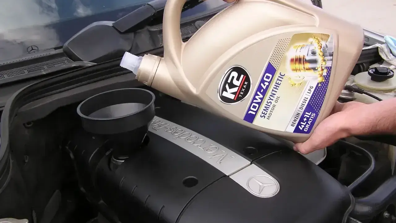 Wlewanie oleju silnikowego K2 10W-40 do silnika Mercedesa. Różne rodzaje olejów silnikowych są kluczowe dla jego pracy.