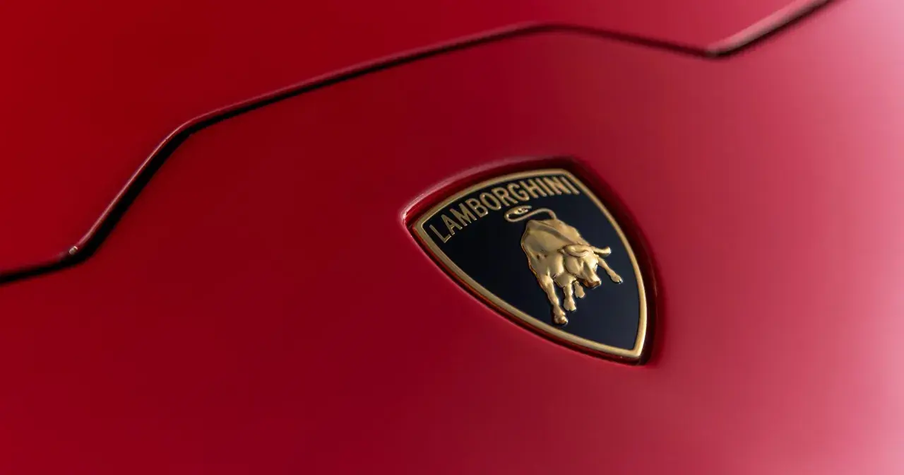 Złoty byk na czarnym tle z napisem "Lamborghini" - tak wygląda znaczek tej marki na czerwonej karoserii.