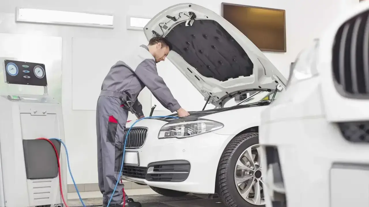 Mechanik sprawdza klimatyzację auta. Dowiedz się, ile kosztuje przegląd auta i jego serwis.