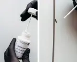 Rękawiczka z czarną rękawiczką nakłada lakier zaprawkowy na drobne uszkodzenie. Kolor to RAL 9005.