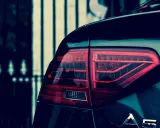 Czerwone światło tylne samochodu Audi A5, z widocznym napisem A5. Polimocznikowa obudowa lampy lśni w ciemności.