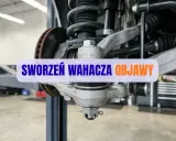 Widok na zawieszenie samochodu z widocznymi sworzeniami wahacza. Napis "SWORZEŃ WAHACZA OBJAWY" sugeruje problemy z tym elementem.
