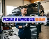 Mechanik w warsztacie samochodowym trzyma przegub. Na ekranie napis "Przegub w samochodzie objawy".