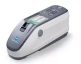 Nowoczesny spektrofotometr Konica Minolta z ekranem LCD, gotowy do precyzyjnych pomiarów koloru.