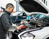 Mechanik sprawdza stan akumulatora, przygotowując samochód do przeglądu. Opłata za przegląd samochodu obejmuje takie diagnostyki.