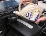 Wlewanie oleju silnikowego K2 10W-40 do silnika Mercedesa. Różne rodzaje olejów silnikowych są kluczowe dla jego pracy.