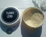 Otwarty pojemnik z jasnym proszkiem, na wieczku napis "TLENEK CERU".