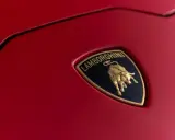 Złoty byk na czarnym tle z napisem "Lamborghini" - tak wygląda znaczek tej marki na czerwonej karoserii.