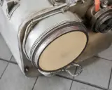 Element układu wydechowego, prawdopodobnie filtr DPF, gotowy do wypalania. Widoczny ceramiczny wkład.