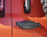 Pomarańczowy lakier lśni, a czarne, wyraziste logo "RAPTOR" z pazurami podkreśla jego dziką naturę.