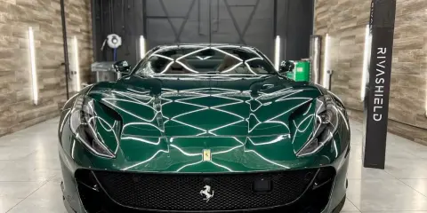 Lśniące, zielone Ferrari z powłoką ceramiczną na auto, prezentujące się w profesjonalnym studiu detailingowym.