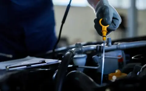 Mechanik sprawdza poziom oleju, co może pomóc wykryć nieszczelna odma objawy.