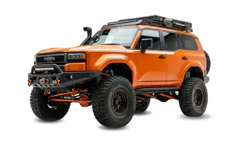 Pomarańczowy Toyota z terenowym wyposażeniem, wyciągarką i bagażnikiem dachowym. Zastanawiasz się, ile kosztuje malowanie auta Raptor?