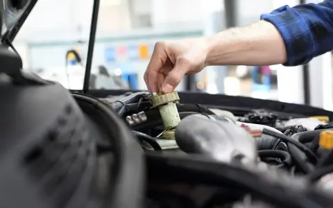 Mechanik sprawdza płyn hamulcowy. Pamiętaj o regularnych przeglądach, aby uniknąć problemów, np. brak przeglądu powyżej 30 dni.
