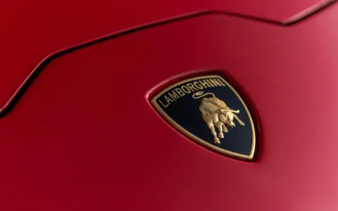 Złoty byk na czarnym tle z napisem "Lamborghini" - tak wygląda znaczek tej marki na czerwonej karoserii.