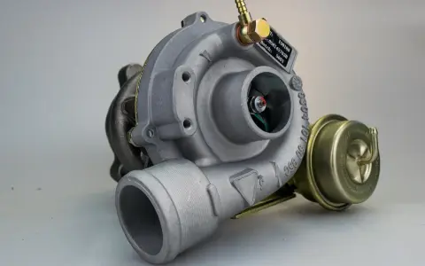 Uszkodzona turbina objawy: metalowy element z wirnikiem, zaworem upustowym i tabliczką znamionową.