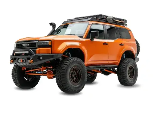 Pomarańczowy Toyota z terenowym wyposażeniem, wyciągarką i bagażnikiem dachowym. Zastanawiasz się, ile kosztuje malowanie auta Raptor?