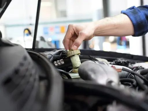 Mechanik sprawdza płyn hamulcowy. Pamiętaj o regularnych przeglądach, aby uniknąć problemów, np. brak przeglądu powyżej 30 dni.