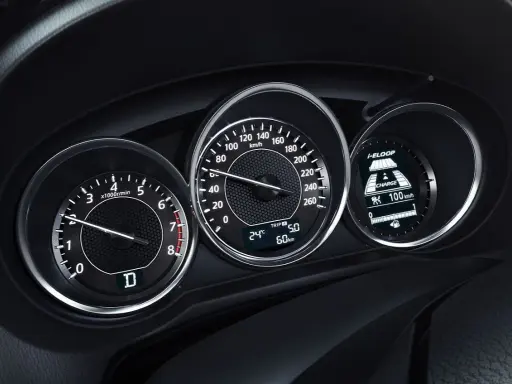 Deska rozdzielcza z obrotomierzem, prędkościomierzem i wyświetlaczem i-ELOOP. Widać falujące obroty silnika i prędkość 100 km/h.