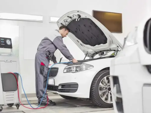 Mechanik sprawdza klimatyzację auta. Dowiedz się, ile kosztuje przegląd auta i jego serwis.