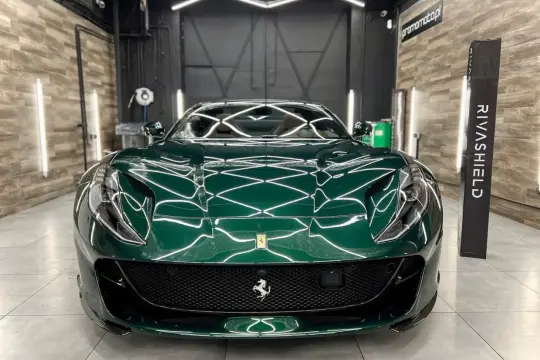 Lśniące, zielone Ferrari z powłoką ceramiczną na auto, prezentujące się w profesjonalnym studiu detailingowym.