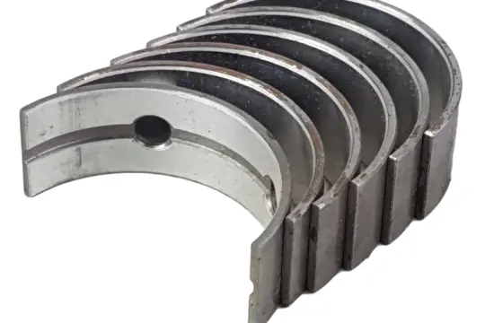 Kilka metalowych panewek Kolbenschmidt, gotowych do montażu w silniku.