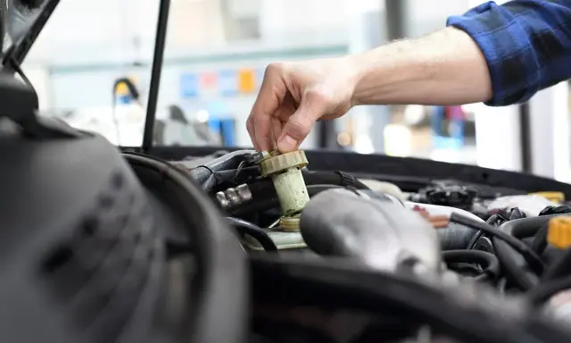 Mechanik sprawdza płyn hamulcowy. Pamiętaj o regularnych przeglądach, aby uniknąć problemów, np. brak przeglądu powyżej 30 dni.