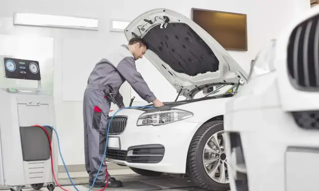 Mechanik sprawdza klimatyzację auta. Dowiedz się, ile kosztuje przegląd auta i jego serwis.