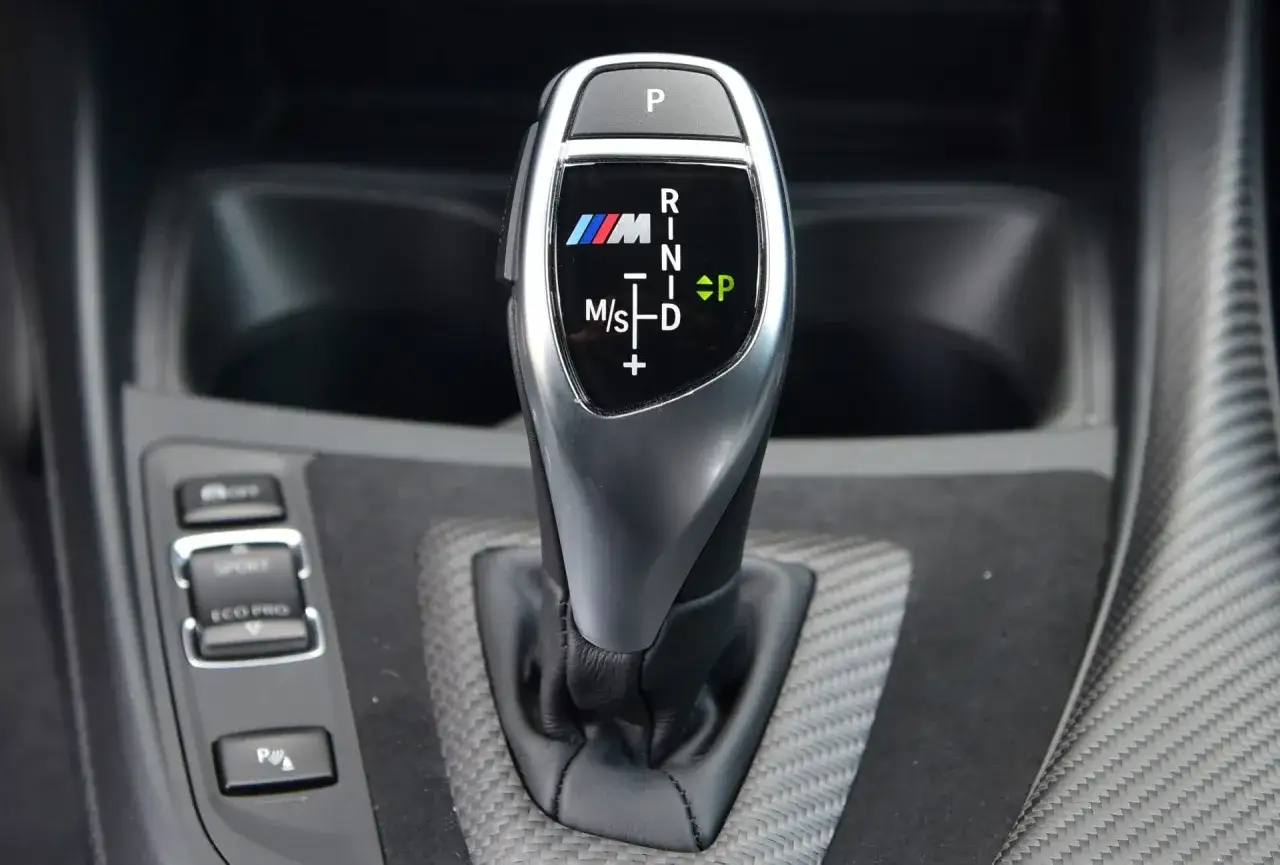 Dźwignia zmiany biegów w BMW M z trybami jazdy: P, R, N, D, M/S. Wygodne biegi w automacie.