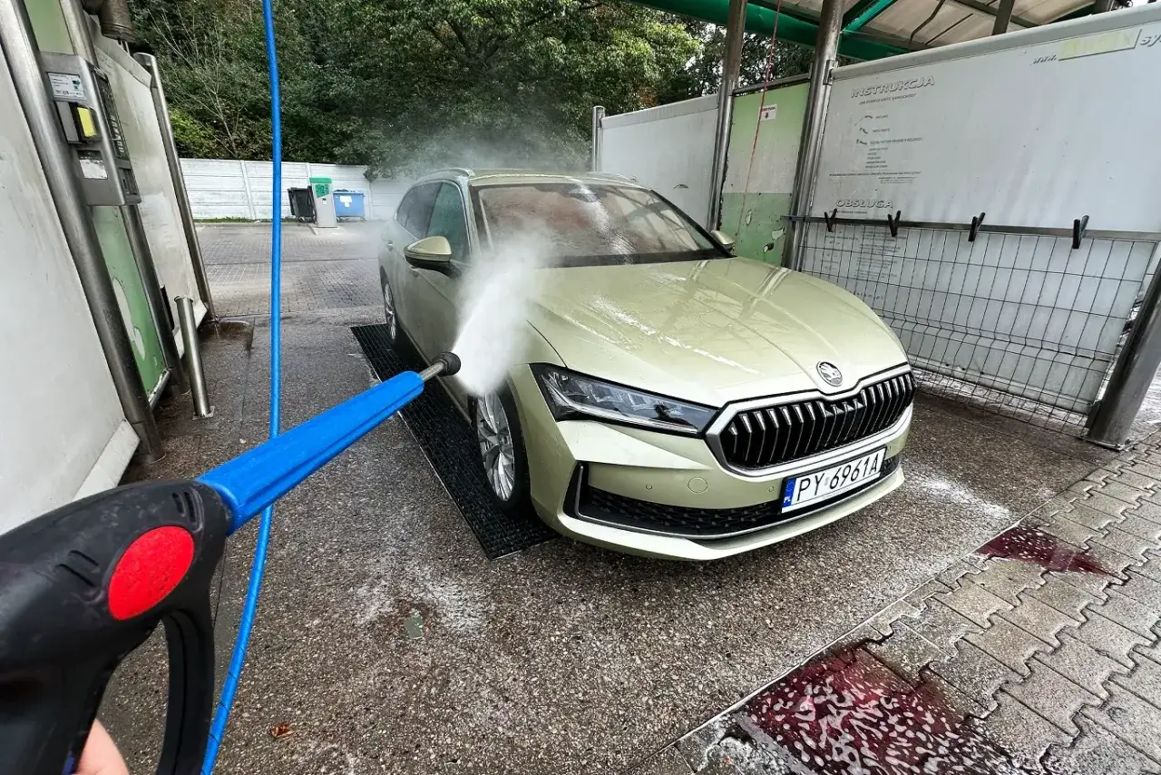 Mycie auta na samoobsługowej myjni. Woda pod ciśnieniem skutecznie usuwa brud, a pytanie czym zmyć żywicę z lakieru staje się mniej palące.