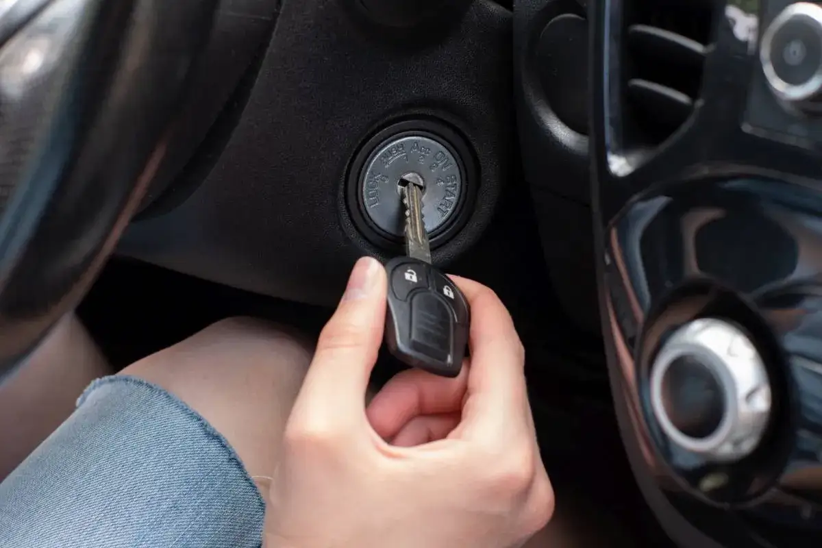 Dłoń wkłada kluczyk do stacyjki, aktywując immobilizer i przygotowując auto do jazdy.