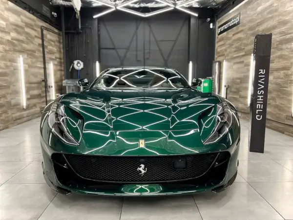 Lśniące, zielone Ferrari z powłoką ceramiczną na auto, prezentujące się w profesjonalnym studiu detailingowym.